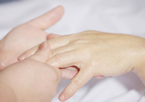 Ręce masażysty wykonujące masaż dłoni pacjenta